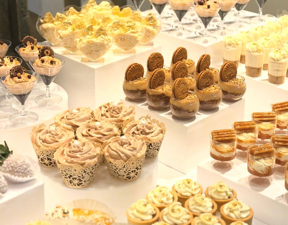 Dessert display of rose-swirled cupcakes, caramel parfaits and cookie-topped mousses