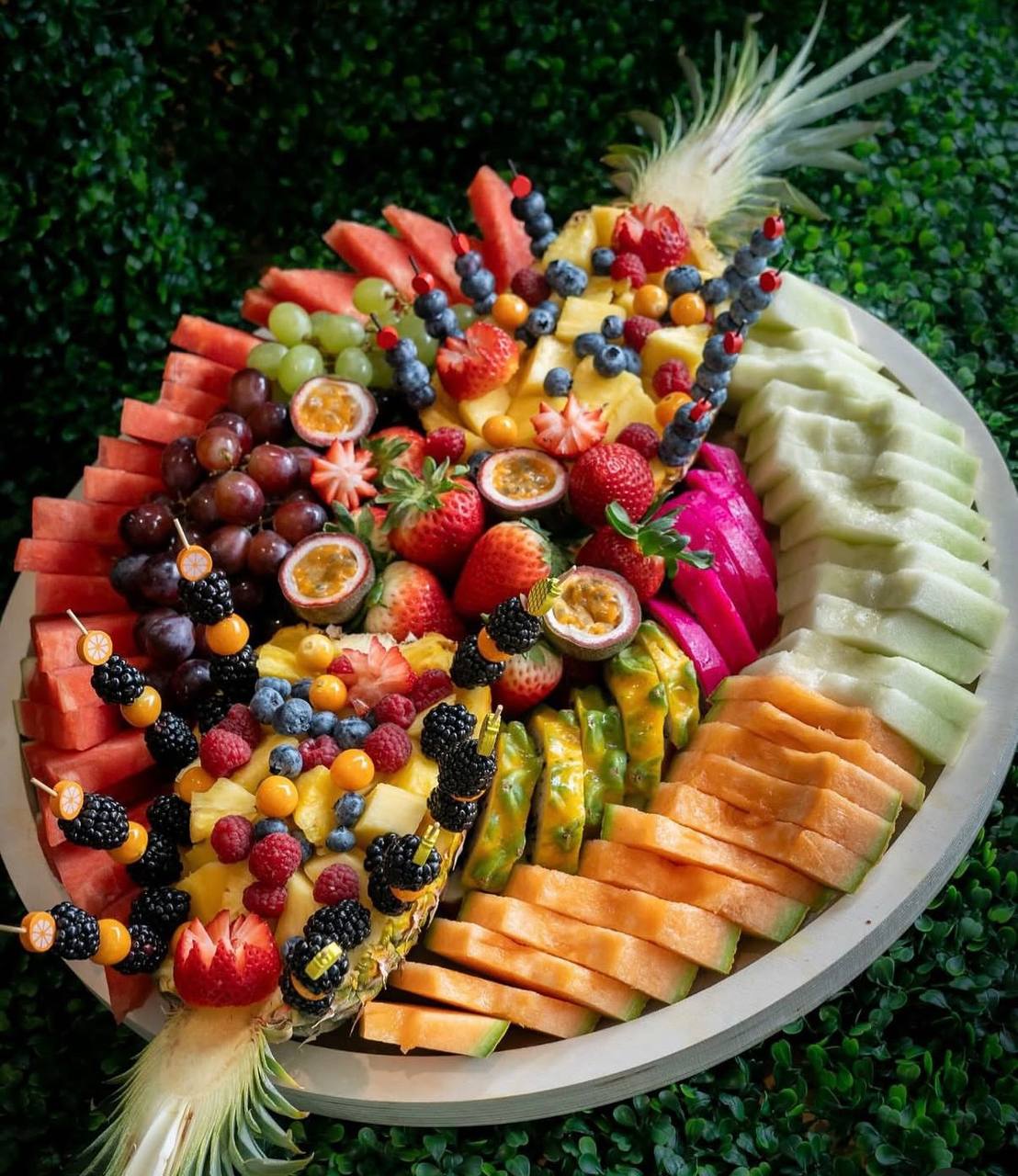 Rainbow fruit platter carved from pineapple, watermelon, dragon fruit and berries